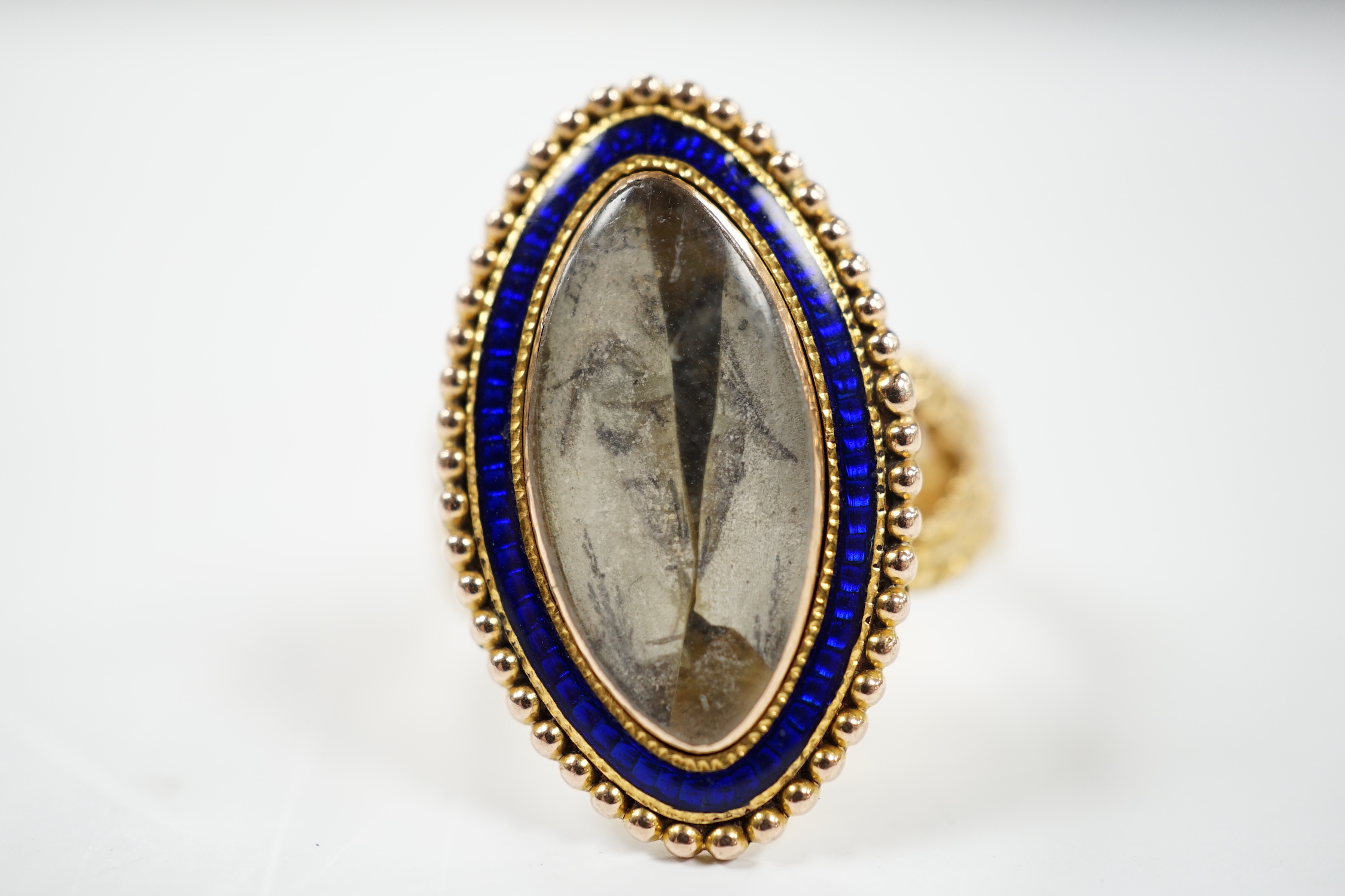 A 19th century 15ct and blue enamel set navette shaped mourning ring, with damaged inset ivory panel, size O, gross weight 5.5 grams. Submission reference Q8ZGC6ZR